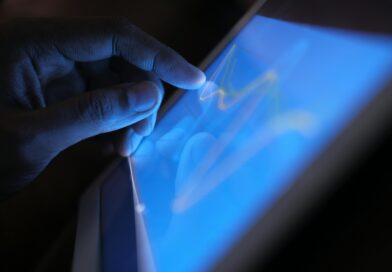 Close-up of a hand interacting with a touch screen tablet, showcasing modern technology use.