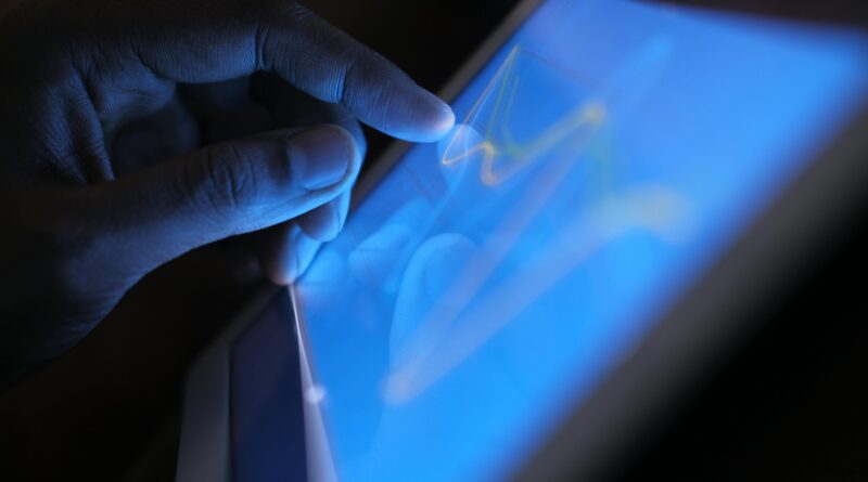 Close-up of a hand interacting with a touch screen tablet, showcasing modern technology use.